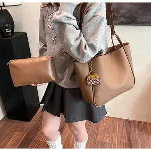 Brown tote bag and pouch set with leopard print charm in a lifestyle interior setting