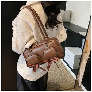 Detail of deep brown retro shoulder bag featuring sleek leather texture and bow accents