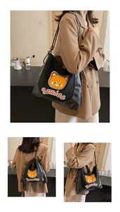Détail du sac à bandoulière noir avec broderie ours et bandoulière chaîne élégante