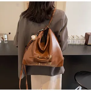 Brown vintage large capacity tote bag with baseball pendant shown on model in a cafe
