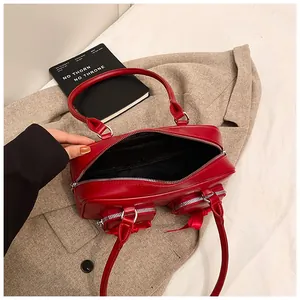 Detail view of red shoulder bag interior with bow accents and zip pockets