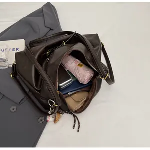 Top-down view of retro dark brown tote bag interior with umbrella, notebook, and wallet