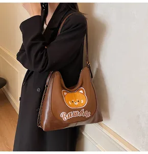 Détail du sac hobo avec broderie ours et texte Bamboa sur cuir marron de qualité