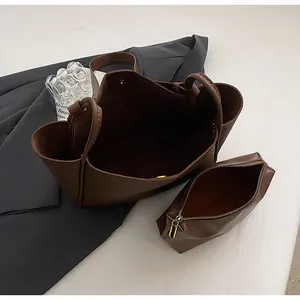 Detail view of large dark brown tote bag with matching inner zipper pouch and magnetic closure
