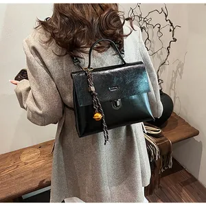 Detailansicht der schwarzen Ledertasche mit goldener Schnalle und Flechtgriff