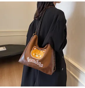 Détail du sac cabas marron en PU avec broderie ours jaune et chaîne en métal élégante