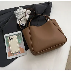 Detailed texture of brown pebble leather tote bag with commuter styling and slim straps