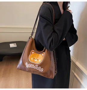 Détail du cabas en cuir marron foncé avec broderie ours et texte bamboo sur le devant