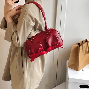 Red retro underarm bag for women featuring decorative zippers and silk bow detail