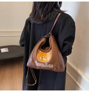 Vue détaillée du sac cabas marron avec patch chat et détail de chaîne en métal élégant