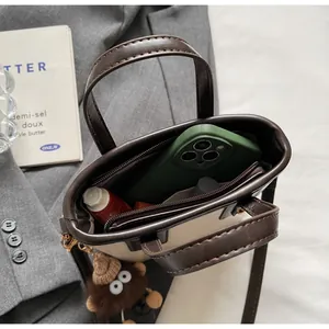 Détail de l'intérieur d'un mini sac bicolore avec rangement pour mobile et rouge à lèvres