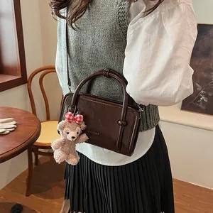 Retro dark brown leather crossbody bag for women with a cute plush bear pendant