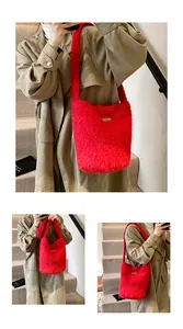 Close-up of red plush faux fur tote bag with brown leather label and wide shoulder strap