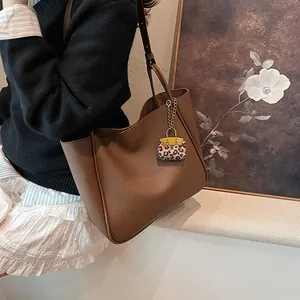 Large dark brown pebble leather tote bag with stylish leopard print charm accessory