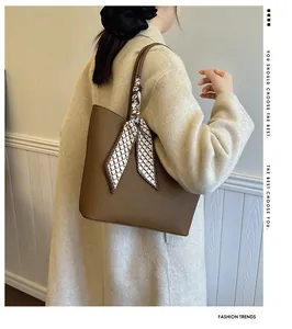 Sac fourre-tout marron grainé avec foulard géométrique porté par un mannequin en manteau beige