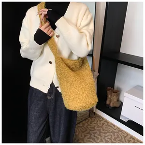 Detailed view of yellow faux fur tote bag with wide strap paired with casual autumn outfit