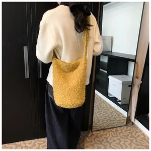Detail of yellow plush fleece bucket bag with soft texture and matching shoulder strap