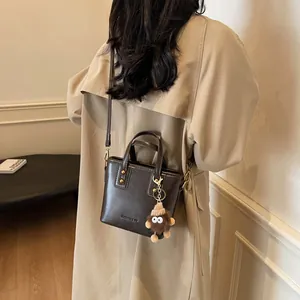 Sac seau en cuir marron foncé avec pendentif monstre en peluche très élégant