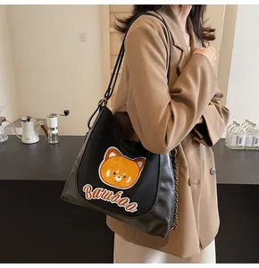Détail du sac cabas en similicuir noir avec patch animal orange et bandoulière