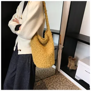 Detail of ginger plush bucket bag with soft faux fur texture and wide shoulder strap