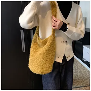 Detail of yellow plush shoulder bag showing soft fuzzy texture and large hobo capacity