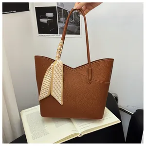 Détail du sac cabas marron texture grainée avec foulard en soie décoratif noué