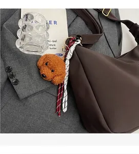 Nahaufnahme braune Tragetasche mit Teddybär-Anhänger und bunten Quasten aus Kordel