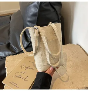 Gros plan d'un mini sac de téléphone en cuir litchi beige avec boucle en métal argenté