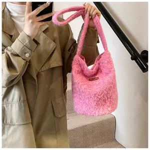Detail of soft fuzzy faux fur shoulder bag in vibrant rose pink with a leather logo patch