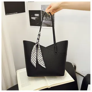 Détail du sac cabas noir texturé litchi avec foulard décoratif et découpe latérale en V