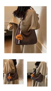 Detailaufnahme der großen dunkelbraunen Leder-Shopper mit schickem Plüsch-Anhänger