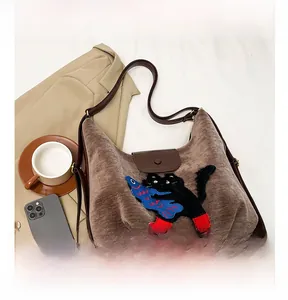 Détail du sac cabas en daim marron avec broderie de chat noir de style vintage chic