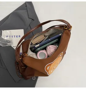 Vue intérieure du sac ours marron montrant sa grande capacité pour parapluie et tablette