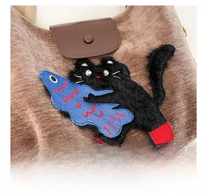 Détail du sac en velours côtelé avec broderie chat noir et poisson bleu avec rabat en cuir