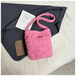 Detailed view of pink plush crossbody bag with leather patch on white textured background