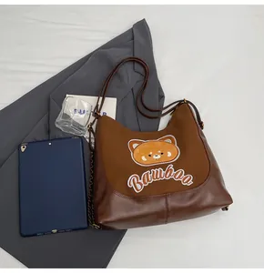Détail d'un sac cabas ours marron avec broderie BAMBOO dans une scène de style de vie