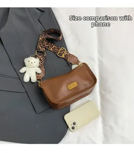 Compact brown leather Boston bag with leopard strap and phone for size comparison