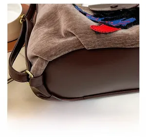 Gros plan sur les coutures contrastées d'un sac vintage avec anneaux dorés
