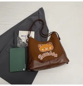 Détail du sac hobo avec un écusson petit panda et lettrage brodé BAMBOO