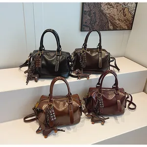 Detail of vintage Boston handbags in four colors with cute charms and glossy texture