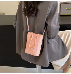 Pink lychee texture leather mini crossbody phone bag shown on a stylish model