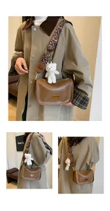 Brown leather Boston bag with leopard print strap and plush bear charm detail