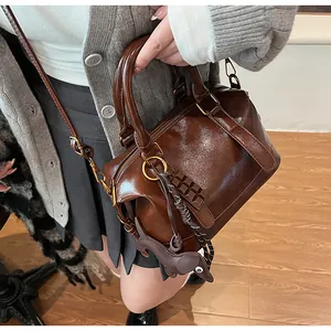 Detailed macro view of the caramel brown oil-wax leather texture and chocolate charms