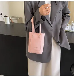 Close-up of pink litchi grain faux leather phone bag with fashion label and front pocket