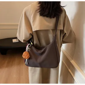 Detail der kaffeebraunen großen Hobo-Tasche mit einem süßen Teddyhund Plüsch-Anhänger