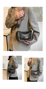 Detail of black pebbled leather Boston bag with leopard print strap and gold hardware