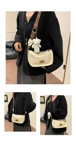 Cream Boston bag with leopard strap and plush bear charm shown on a model