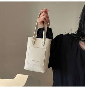 Detail of off-white lychee leather mini tote with stitching and fashion logo