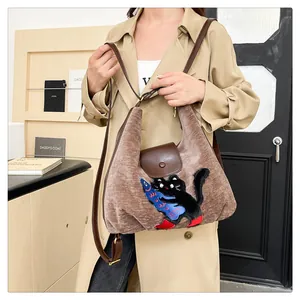 Détail du sac cabas marron pelucheux avec broderie chat noir et bandoulière en cuir