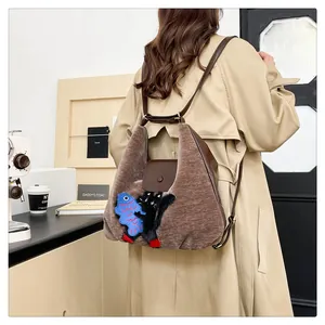 Détail du sac à dos vintage en peluche marron avec motif chat et bretelles en cuir